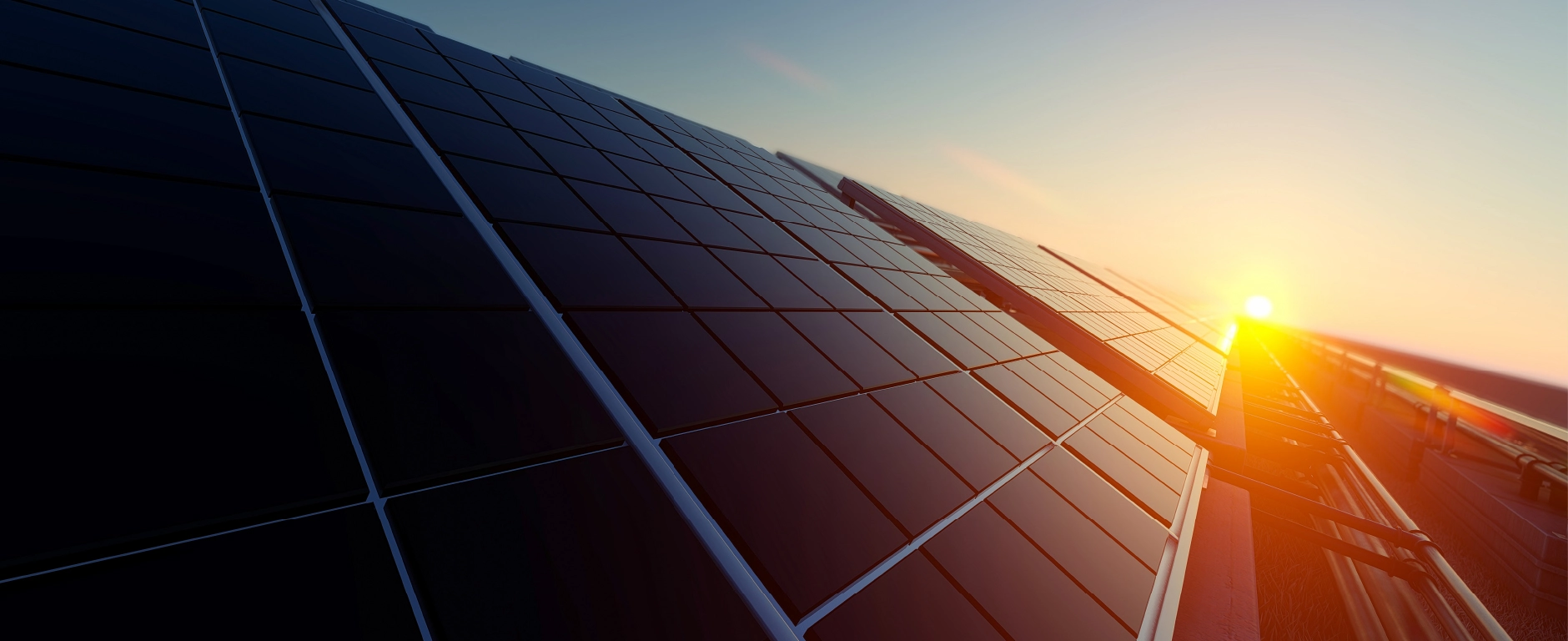 Photovoltaikmodule auf einem Dach mit Sonne im Hintergrund